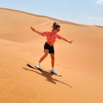 Dubai desert safari Sandboarding kids enjoying