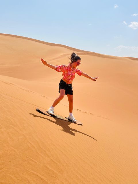 Dubai desert safari Sandboarding kids enjoying