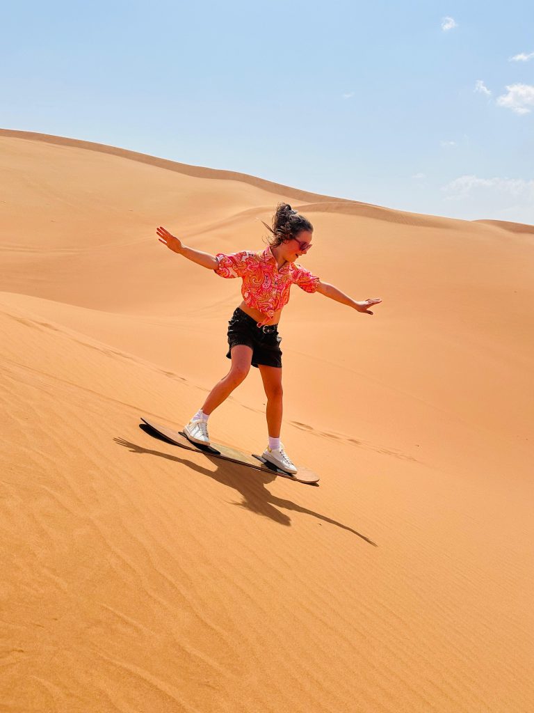 Dubai desert safari Sandboarding kids enjoying